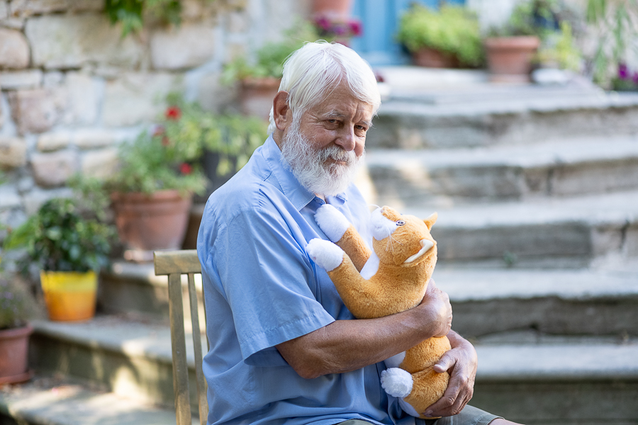 Ein älterer Herr spielt mit der Smart Cat von RobiCare.